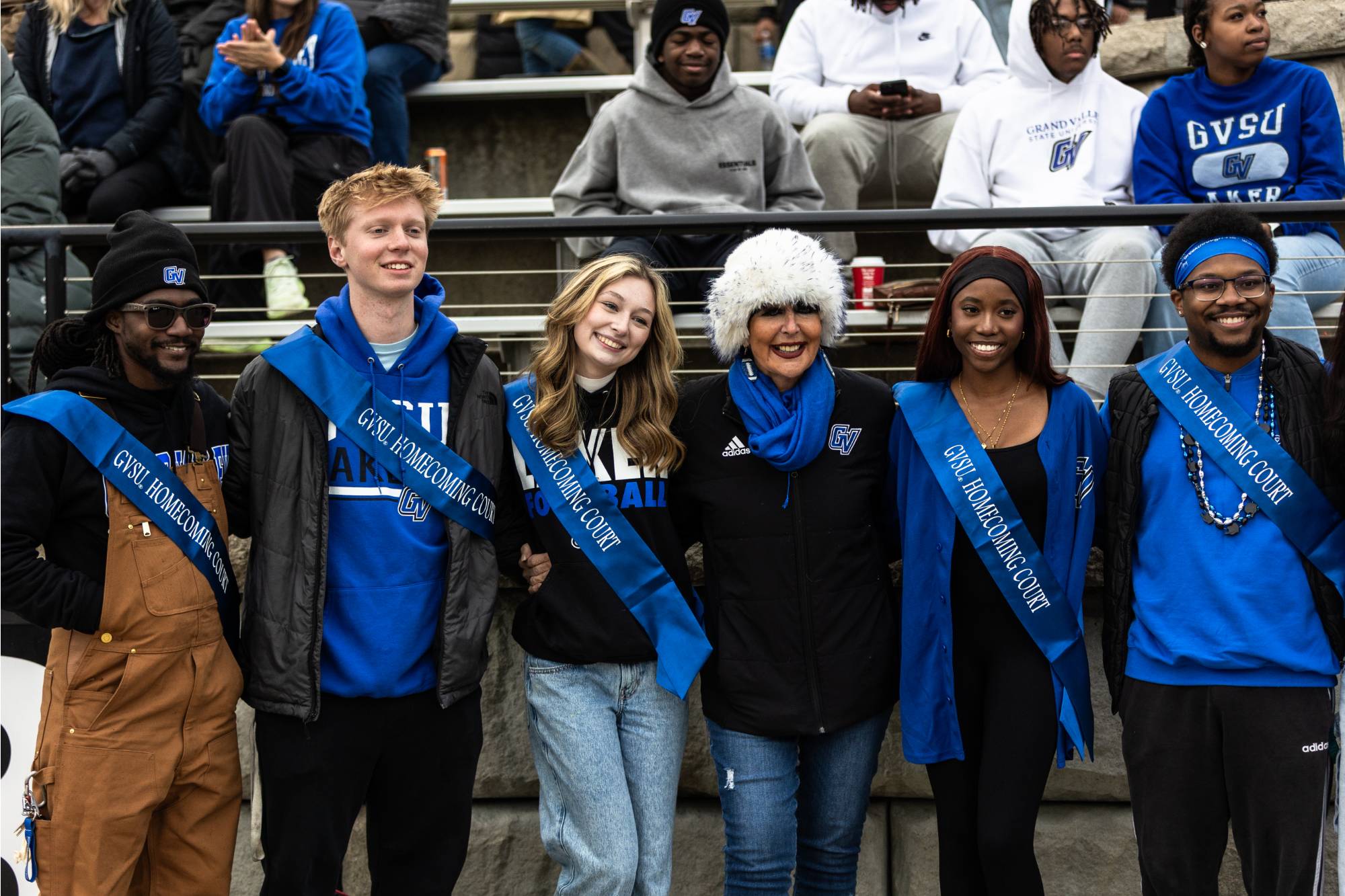 students pose with president mantella while wearing blue sashes
